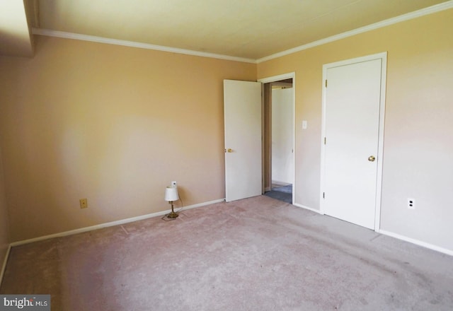unfurnished bedroom with carpet floors, crown molding, and baseboards