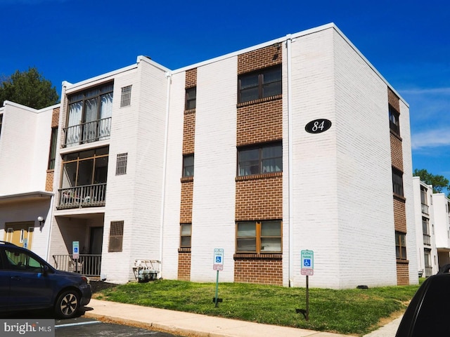view of apartment building / complex featuring uncovered parking