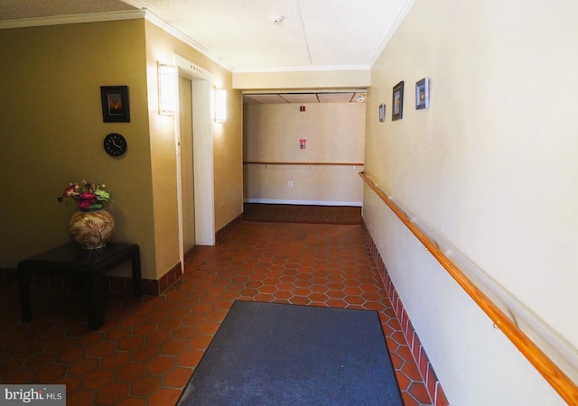hall with ornamental molding and baseboards