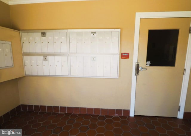 empty room with mail area, baseboards, and electric panel