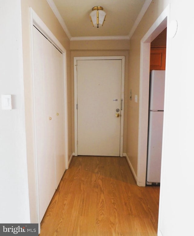 doorway to outside with light wood-style flooring and crown molding