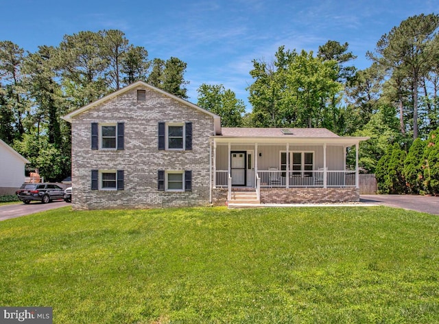 11545 Tomahawk Trl W, Lusby, MD 20657 - tri-level home with covered porch, a front lawn, board and batten siding, and brick siding