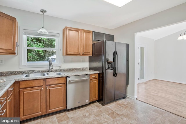 11545 Tomahawk Trl W, Lusby, MD 20657 - kitchen with black fridge, dishwasher, brown cabinets, and hanging light fixtures
