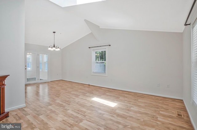 11545 Tomahawk Trl W, Lusby, MD 20657 - unfurnished living room featuring light wood finished floors, a chandelier, lofted ceiling, and a skylight