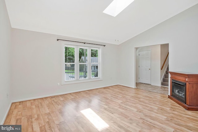 11545 Tomahawk Trl W, Lusby, MD 20657 - unfurnished living room with vaulted ceiling, a skylight, light wood-style floors, and stairs