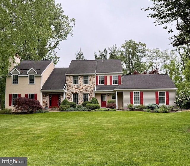 view of front of home with a front yard and stone siding