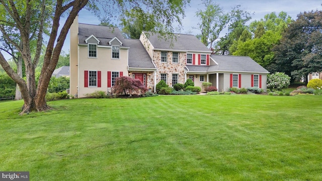 view of front of home with a front yard and stone siding