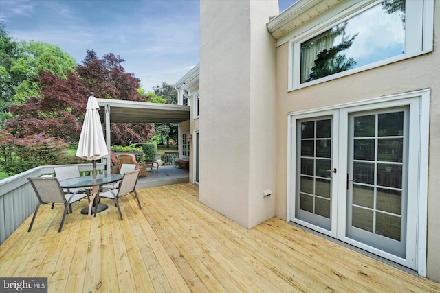 wooden deck featuring outdoor dining space and french doors