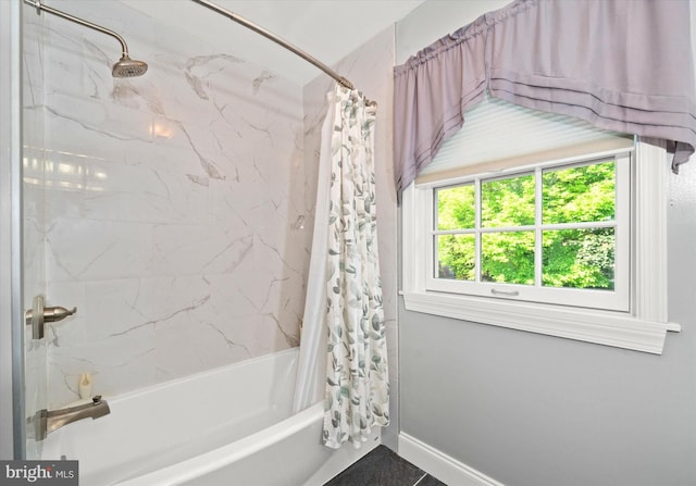 bathroom with shower / bath combination with curtain and baseboards