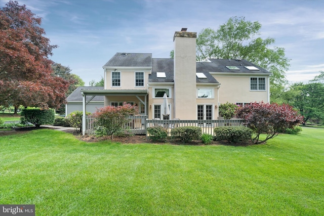 rear view of property featuring a yard, a chimney, and stucco siding