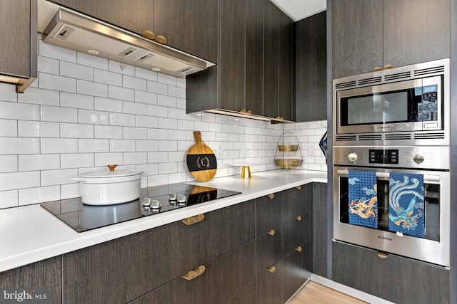 1300 4th St SE Unit 404, Washington, DC 20003 - kitchen with stainless steel appliances, ventilation hood, light countertops, tasteful backsplash, and dark brown cabinets