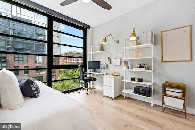 1300 4th St SE Unit 404, Washington, DC 20003 - bedroom featuring wood-type flooring, multiple windows, an office area, expansive windows, and baseboards