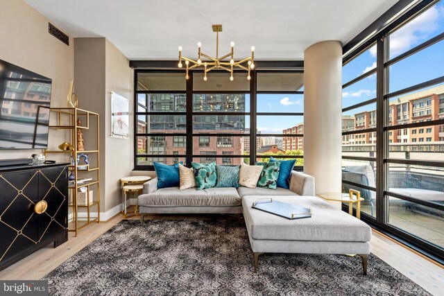 1300 4th St SE Unit 404, Washington, DC 20003 - living area with plenty of natural light, a chandelier, wood finished floors, a wall of windows, and baseboards