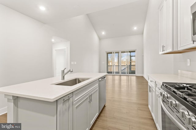 508 Waters Landing Dr, Essex, MD 21221 - kitchen with a sink, appliances with stainless steel finishes, light countertops, a center island with sink, and light wood finished floors