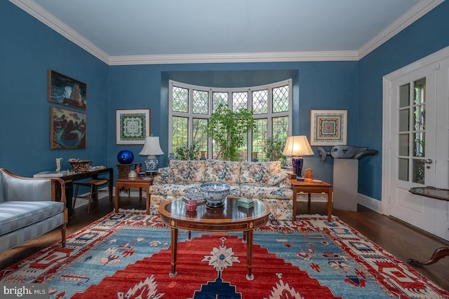 living room with wood finished floors, crown molding, and baseboards