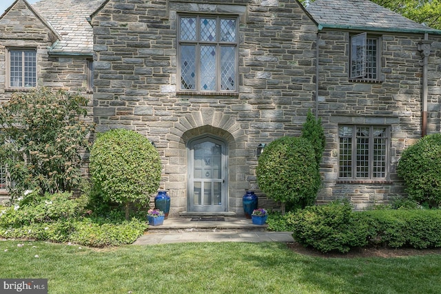 entrance to property featuring a high end roof and stone siding