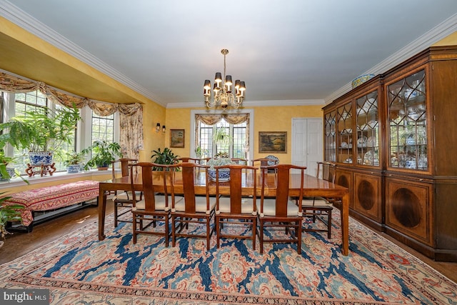 dining area featuring a chandelier, crown molding, and wood finished floors
