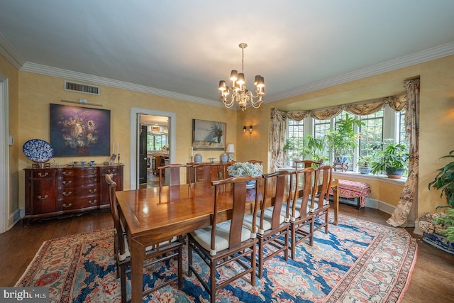 dining space with ornamental molding, wood finished floors, a chandelier, and baseboards