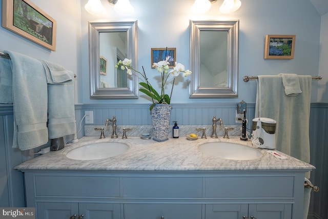 full bathroom featuring double vanity and wainscoting