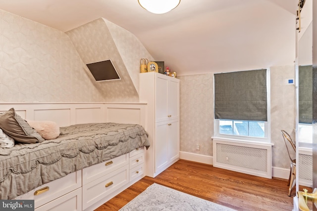 3503 Norris Pl, Alexandria, VA 22305 - bedroom featuring wallpapered walls, radiator heating unit, light wood-style floors, a wainscoted wall, and vaulted ceiling