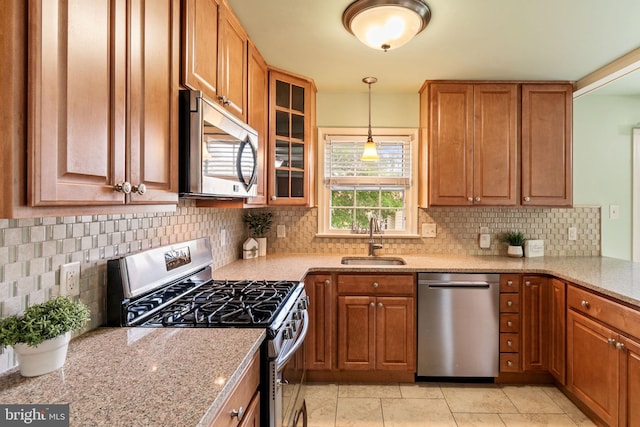 kitchen with stainless steel appliances, a sink, and brown cabinets