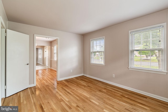 empty room with light wood-type flooring and baseboards