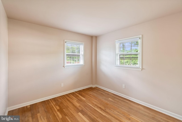 empty room with light wood-type flooring and baseboards