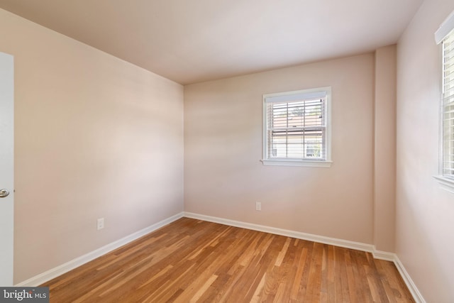 empty room featuring light wood-type flooring and baseboards