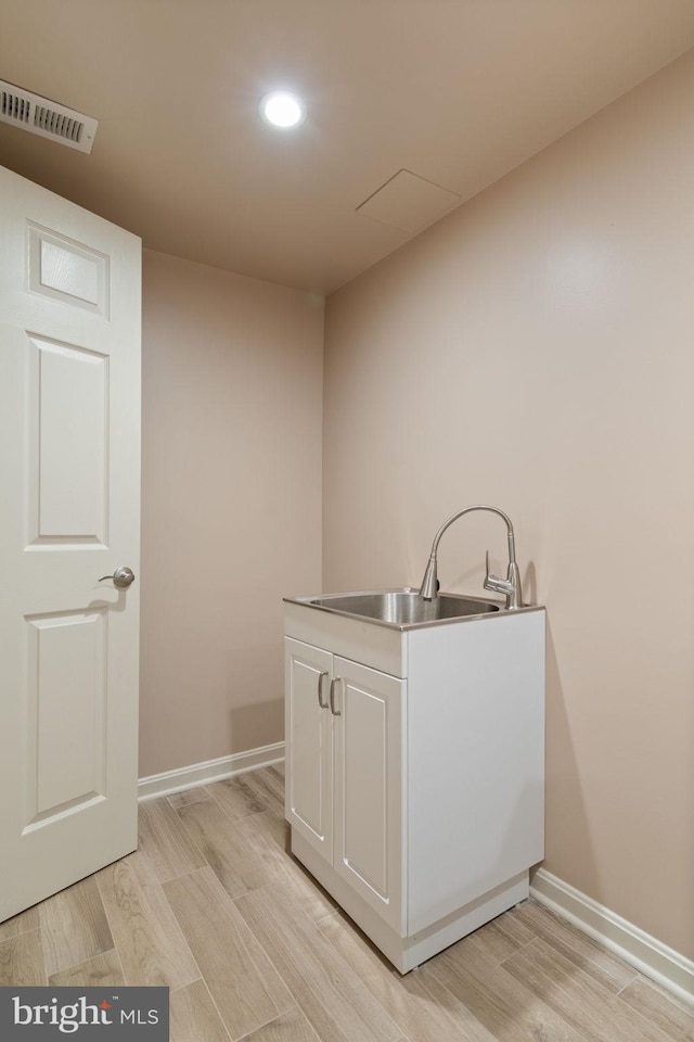 laundry area with a sink, light wood-type flooring, baseboards, and recessed lighting