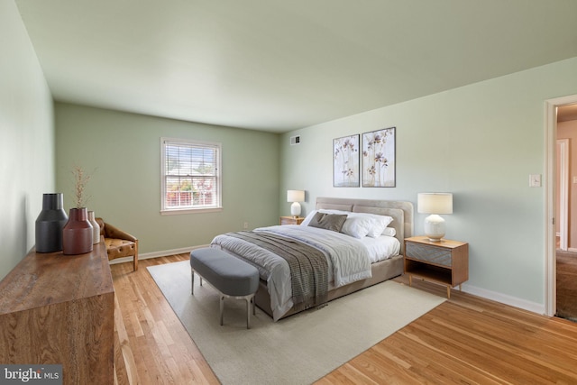 bedroom with light wood-type flooring and baseboards