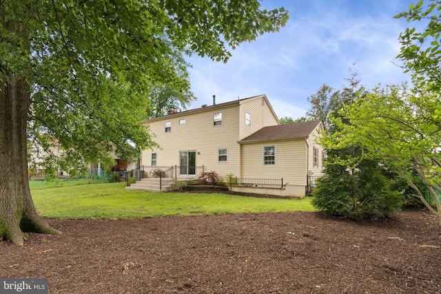 back of house featuring a yard and a chimney