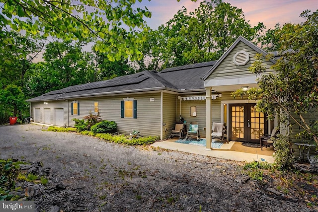 13450 Millstone Cir, Hancock, MD 21750 - rear view of house with french doors, roof mounted solar panels, and a garage