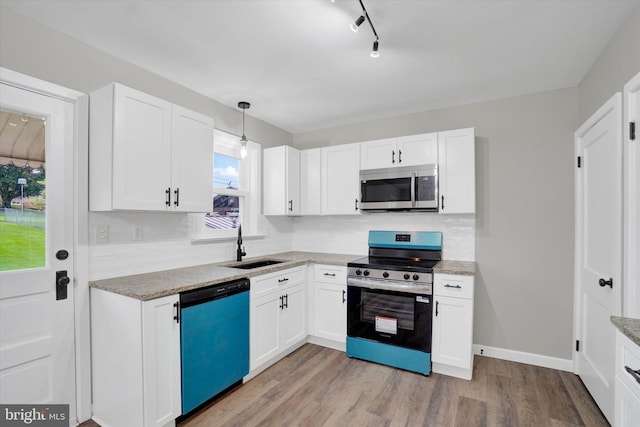 kitchen featuring stainless steel appliances, a sink, decorative backsplash, and white cabinets
