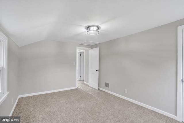 unfurnished bedroom with carpet, vaulted ceiling, and baseboards