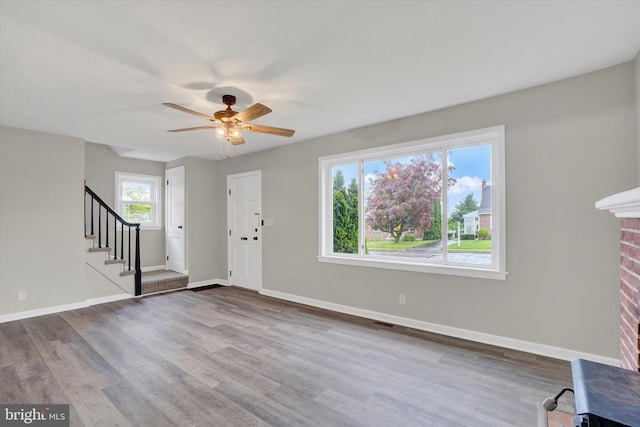 entrance foyer featuring dark wood-type flooring, ceiling fan, stairs, and baseboards