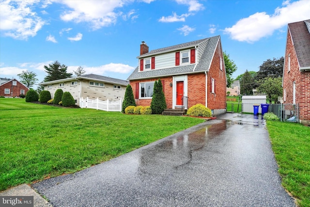 view of front facade featuring a chimney, brick siding, asphalt driveway, a gate, and roof with shingles