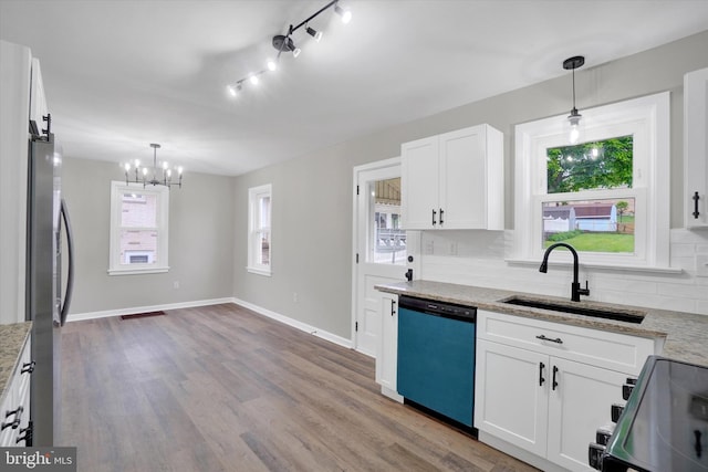 kitchen with dishwashing machine, a sink, a chandelier, range with electric stovetop, and white cabinets