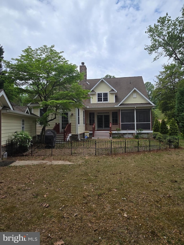 31667 W Edge Rd, Millington, MD 21651 - view of front of house with a chimney, a sunroom, a fenced front yard, and a shingled roof