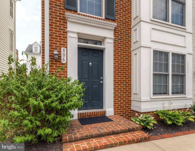 doorway to property with brick siding