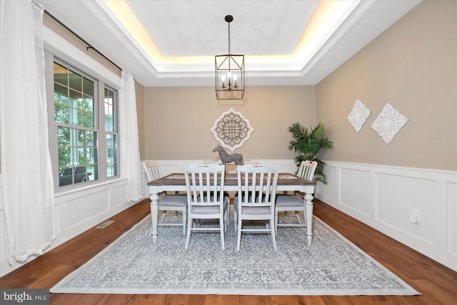 843 Summer Breeze Path, Cochranville, PA 19330 - dining room with a chandelier, a tray ceiling, wood finished floors, wainscoting, and a decorative wall