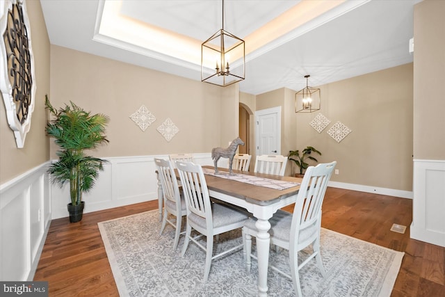 843 Summer Breeze Path, Cochranville, PA 19330 - dining room featuring a chandelier, arched walkways, wainscoting, wood finished floors, and a decorative wall