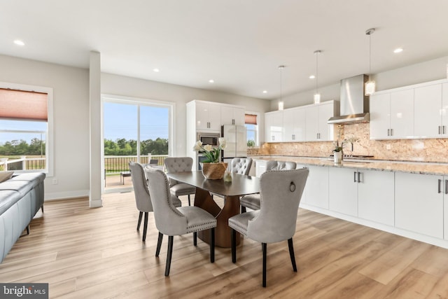 dining space with light wood-type flooring, recessed lighting, and baseboards
