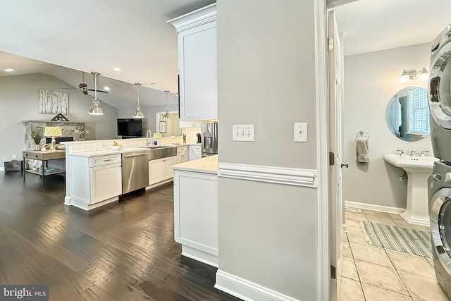 10 Greystone Dr, Lewes, DE 19958 - kitchen featuring dishwasher, stacked washing machine and dryer, a peninsula, light countertops, and a sink