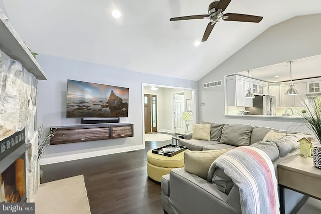 10 Greystone Dr, Lewes, DE 19958 - living room with vaulted ceiling, dark wood finished floors, ceiling fan, recessed lighting, and a warm lit fireplace