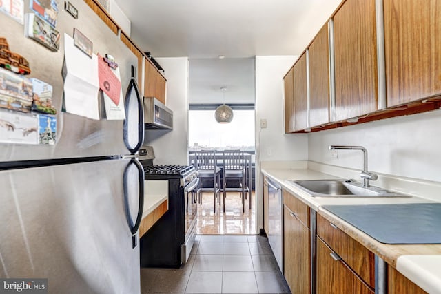 4000 N Charles St Unit 905, Baltimore, MD 21218 - kitchen featuring stainless steel appliances, light countertops, a sink, and brown cabinets