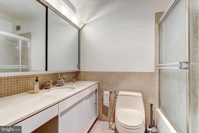 4000 N Charles St Unit 905, Baltimore, MD 21218 - bathroom featuring vanity, tile walls, toilet, tile patterned floors, and wainscoting