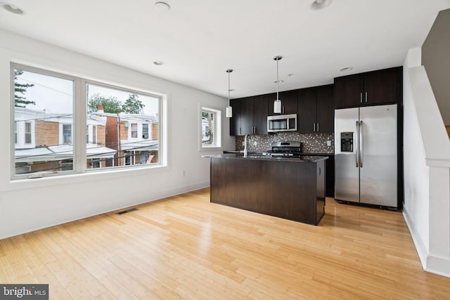 315 Dupont St, Philadelphia, PA 19128 - kitchen with stainless steel appliances, decorative backsplash, a center island with sink, light wood-type flooring, and recessed lighting