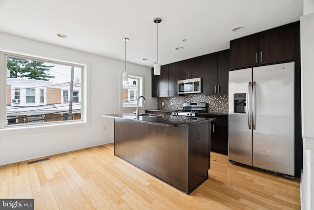 315 Dupont St, Philadelphia, PA 19128 - kitchen with stainless steel appliances, an island with sink, light wood finished floors, decorative backsplash, and recessed lighting