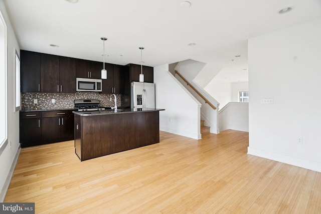 315 Dupont St, Philadelphia, PA 19128 - kitchen with stainless steel appliances, dark countertops, light wood finished floors, tasteful backsplash, and open floor plan