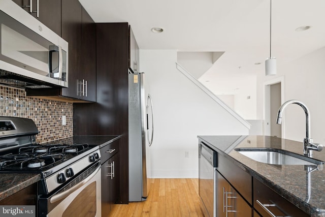 315 Dupont St, Philadelphia, PA 19128 - kitchen with appliances with stainless steel finishes, dark stone countertops, tasteful backsplash, light wood-type flooring, and recessed lighting